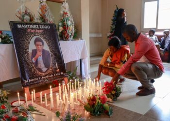 En esta foto de archivo tomada el 23 de enero de 2023, los dolientes colocan velas en una sala de Radio Amplitude FM donde se ha colocado un retrato del periodista Martínez Zogo para rendirle homenaje. Foto: AFP