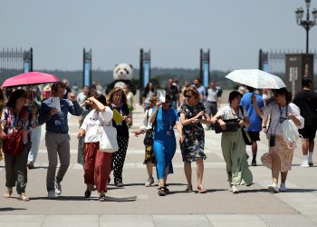 Los turistas se protegen del sol mientras visitan el Palacio Real en el centro de la ciudad de Madrid bajo temperaturas muy altas, el 26 de junio de 2023, cuando España se enfrenta a su primera ola de calor del verano, con temperaturas que se espera que superen los 44 grados localmente en el sur del país