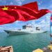 La gente ondea banderas de Camboya (derecha) y China (izq.) mientras el buque escuela chino Qijiguang se prepara para atracar con una pancarta que dice "Traer paz y amistad para encontrar buenos amigos" durante una ceremonia de bienvenida en el puerto de Sihanoukville, en la provincia de Preah Sihanouk, el 19 de mayo. , 2024. - Dos buques de guerra chinos atracaron en Camboya el 19 de mayo de 2024 como parte de los mayores ejercicios militares conjuntos jamás realizados con la nación del sudeste asiático. (Foto de AFP)