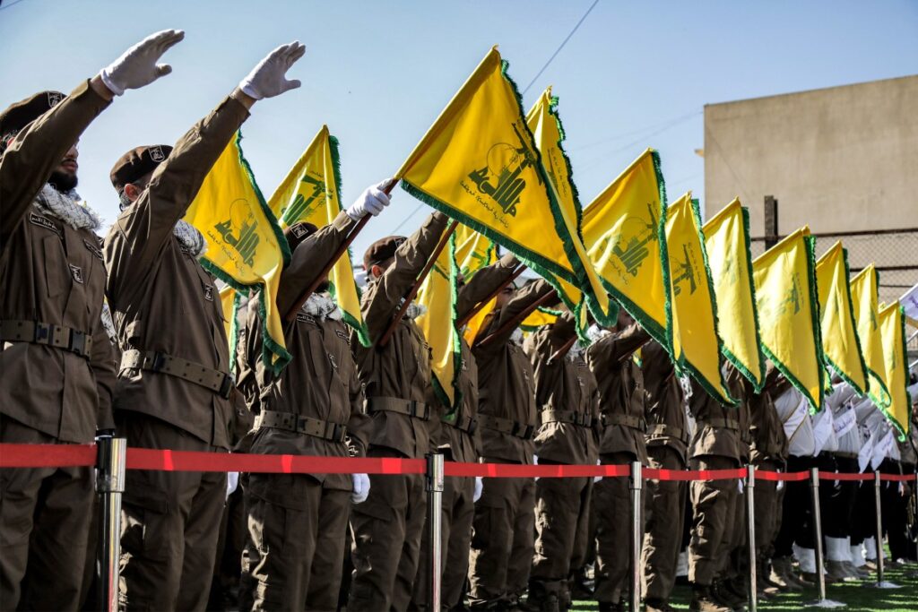 Los miembros de Hezbollah saludan y izan las banderas amarillas del grupo durante el funeral de sus camaradas caídos Ismail Baz y Mohamad Hussein Shohury, que murieron en un ataque israelí a sus vehículos, en Shehabiya, en el sur del Líbano, el 17 de abril de 2024. (Foto de AFP)