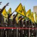 Los miembros de Hezbollah saludan y izan las banderas amarillas del grupo durante el funeral de sus camaradas caídos Ismail Baz y Mohamad Hussein Shohury, que murieron en un ataque israelí a sus vehículos, en Shehabiya, en el sur del Líbano, el 17 de abril de 2024. (Foto de AFP)