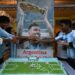 Los miembros del club de aficionados al fútbol argentino celebran el 37 cumpleaños del futbolista argentino Lionel Messi frente a un cartel con su imagen, en Calcuta el 24 de junio de 2024. (Foto de DIBYANGSHU SARKAR / AFP)